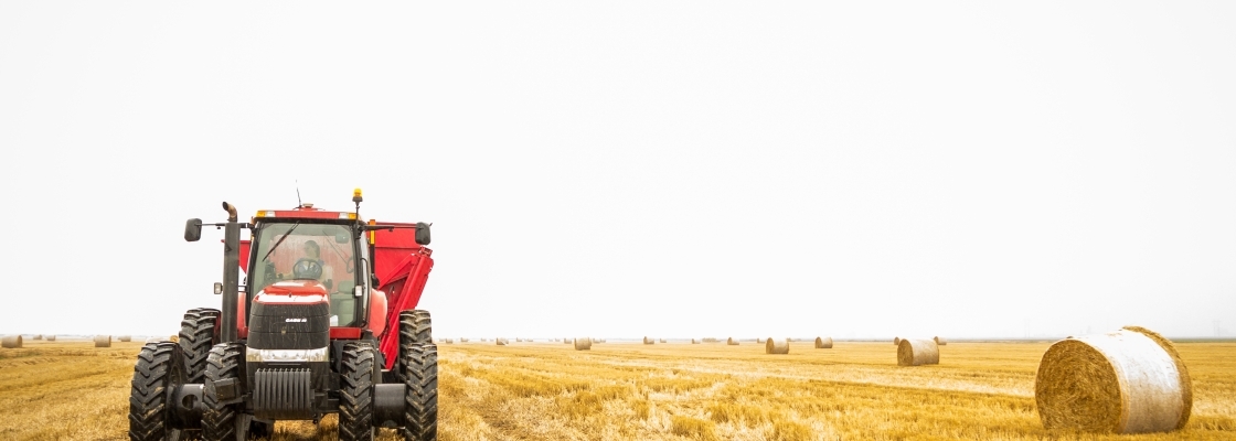 a tractor rolling the hay into hay bails